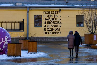 A couple of people walking in front of a building