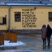 A couple of people walking in front of a building